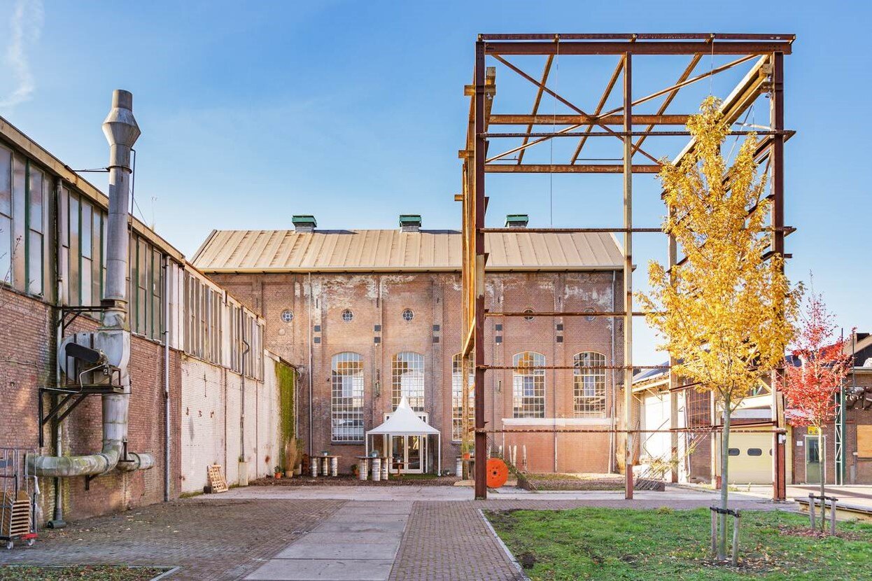 Outside Yada Yada2 "Yada Yada event space at Taets Art and Event Park in Amsterdam and Zaandam, an industrial venue perfect for weddings, conferences, dinners, dance events, and more, set in a historic munitions factory."